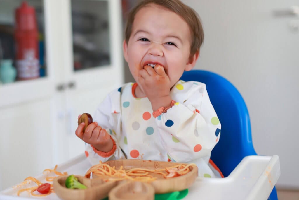 Bebé comiendo espaguetis con las manos